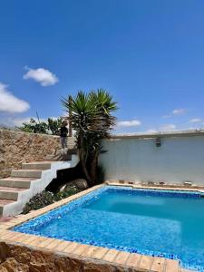 - une piscine avec un palmier à côté d'un bâtiment dans l'établissement Cortijo Bernardino, à Chirivel