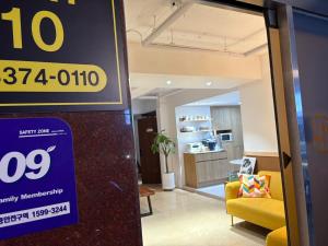 a store sign in a lobby with a yellow couch at stay110 in Seoul