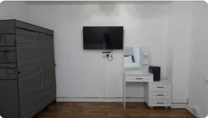 a white room with a tv on a wall at Kingdom Residence in Manchester