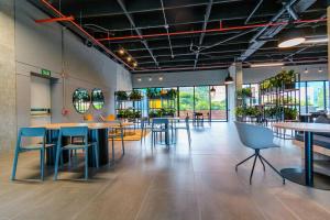 Un restaurante con mesas y sillas en una sala. en Hermosa Suite CoWork - Gym-WifI El Poblado, en Medellín