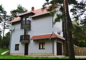 a white house with balconies on the side of it at Apartmani vila Todor in Divčibare