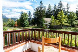 a wooden chair sitting on a balcony with a view at Residence Dei Medici-La casa nel parco in Pescasseroli
