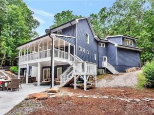 a large blue house with a porch and a patio at Georgia Lakeside Getaway with Private Pool in Flowery Branch