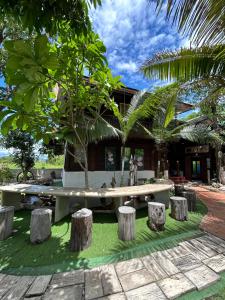 a park with a bench and tree stumps in front of a building at Boon Homestay & Cafe บุญโฮมสเตย์ in Ban Buak Khang