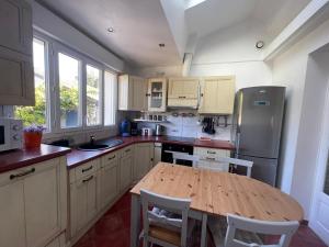 a kitchen with a wooden table and a refrigerator at Maison lumineuse et élégante in Chartres +24 photos