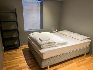 a bedroom with a bed with white sheets and a window at Two-Bedroom City Apartment with Fire Place, Free Parking and Fjordview Terrace - Calm and Central in Ålesund