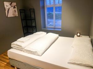 two beds in a room with white sheets and a window at Two-Bedroom City Apartment with Fire Place, Free Parking and Fjordview Terrace - Calm and Central in Ålesund