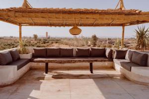 a couch on a patio with a view of the desert at Villa de luxe in Marrakech