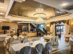 ein Restaurant mit weißen Tischen und Stühlen und einer Bar in der Unterkunft Hotel Viwaldi in Baruchowo