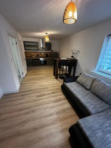 a living room with a couch and a table at Pension Alina auf der Alb in Erkenbrechtsweiler