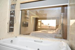 a bathroom with a large mirror over a bath tub at Pyramids Enigma Grand Lodge in Cairo