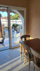 an open patio door with a table and chairs at Casa Valdi, fantastic 4 bedroom house with private,heated swimming pool and barbecue in Ciudad Quesada