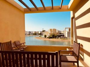 a balcony with chairs and a view of a pool at Sunset Haven in Tawila TownHouse in Hurghada