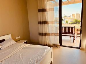 a bedroom with a bed and a view of a patio at Sunset Haven in Tawila TownHouse in Hurghada +26 photos