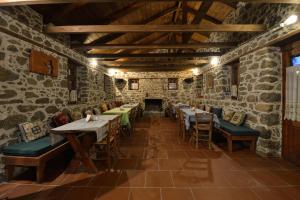 a dining room with tables and chairs and a fireplace at MILOS Guesthouse - Prespa in Mileón