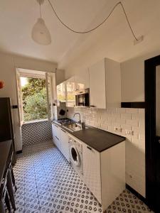 una cucina con lavello e lavatrice di The Place Strozzi a Roma