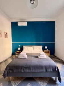 una camera da letto con un letto grande con una parete blu di The Place Strozzi a Roma