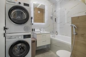 a bathroom with a washer and a sink and a washing machine at Arena Gold Penthouse in Oradea