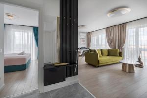 a hotel room with a bed and a yellow couch at Arena Gold Penthouse in Oradea