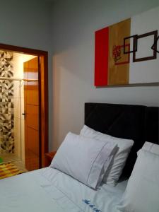 una camera da letto con un letto con cuscini bianchi di Ilha do Sol a Arraial d'Ajuda