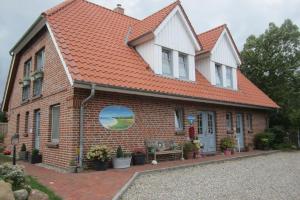a small brick house with an orange roof at Haus-Sahrensdorf in Fehmarn