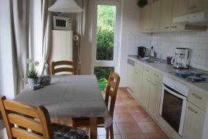 a kitchen with a table and a table and chairs at Haus-Sahrensdorf in Fehmarn