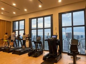 a gym with people exercising on tread machines in front of windows at Luxury Suite Lucentia BBCC Infinity Pool in Kuala Lumpur