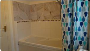 a bathroom with a tub and a shower curtain at Family Friendly Room in Manchester