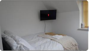 a bedroom with a bed with a tv on the wall at Family Friendly Room in Manchester
