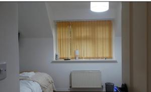 a bedroom with a bed and a window with a radiator at Family Friendly Room in Manchester