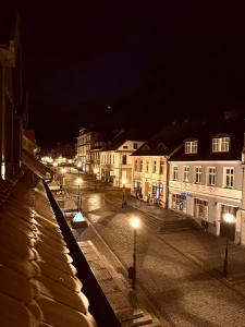 una calle de la ciudad por la noche con edificios y luces de la calle en Apartament Zielony Stół, en Gniezno