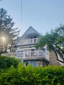 a large white house with a balcony on it at Villa Julia in Velence