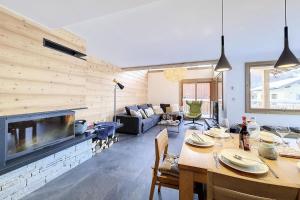 un soggiorno con tavolo e camino di Résidence Le Bettex - Chalet TY MENEZ MAE-9634 a Praranger