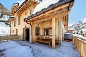 una casa in legno con un tavolo su una terrazza di Résidence Le Bettex - Chalet TY MENEZ MAE-9634 a Praranger