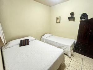 a bedroom with two beds and a dresser at Jireh Antigua in Antigua Guatemala