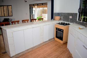 a kitchen with white cabinets and a stove top oven at Tropical lodge in Kakamega