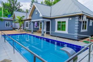 a home with a swimming pool in front of a house at Maili 6 Private Apartments in Moshi