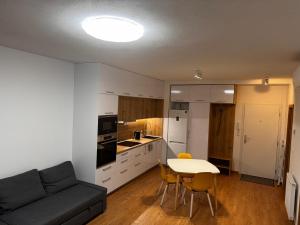 a kitchen and a living room with a couch and a table at Bratislava apartment in Bratislava