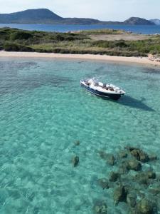 a boat in the water next to a beach at Sleeping on a boat in the Island's bay in Porto San Paolo