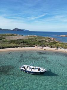 a boat in the water next to a beach at Sleeping on a boat in the Island's bay in Porto San Paolo