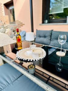 a table with a bottle of alcohol and two glasses at Apartment Bella Petit in Rinderbügen