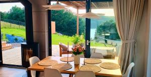 a dining room with a table and a large window at Stodoła Rzym - domek, jacuzzi, sauna, jezioro, las in Kożyczkowo