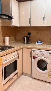 a kitchen with a stove and a washing machine at Elegant 3 bedrooms Villa Relax & Enjoy family only in Jeddah