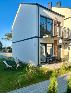 a house with a balcony and a table and chairs at Cosy waves apartment in Tupadła