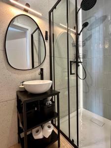 a bathroom with a sink and a shower with a mirror at Cosy waves apartment in Tupadła +14 photos