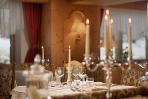 - une table avec des bougies et des verres à vin dans l'établissement Hotel Villa Eden, à Corvara in Badia