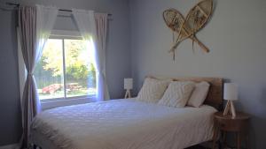 Exclusive Waterfront Cottage في Combermere: غرفة نوم بسرير كبير ونافذة