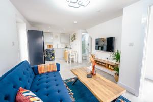 a living room with a blue couch and a table at Amias Homes in Cardiff