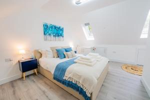 a white bedroom with a bed with towels on it at Amias Homes in Cardiff