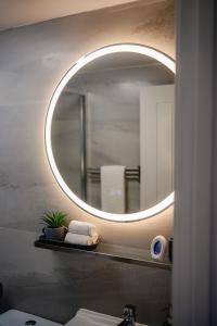 a bathroom with a round mirror and a sink at Amias Homes in Cardiff +18 photos